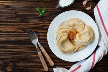 Vareniki or pyrohy, varenyky, dumplings traditional east european pastry dish stuffed with potatoes served with sour cream and caramelized onions. Ukrainian, Polish, Russian cuisine. Wooden background