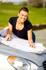 young woman checking the map on her road trip
