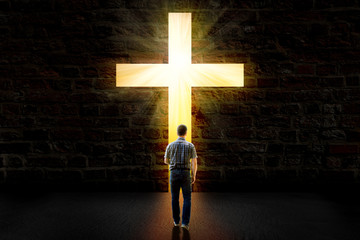 a man walking towards a glowing cross