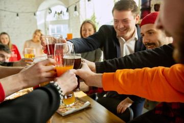 Happy co-workers celebrating while company party and corporate event. Young caucasian people in casual clothes cheering and laughting. Concept of office culture, teamwork, friendship, holidays