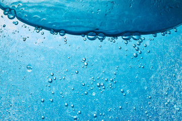 Sparkling Mineral Water Background. Blue bubbles of fresh soda float to the surface of drink to...