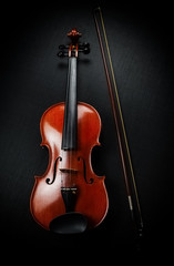 The wooden violin put beside bow,show front side of string instrument,on black canvas background