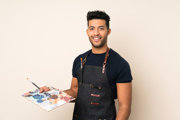 Young handsome man over isolated background holding a palette