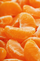 Slices of juicy tangerines close up as background texture.