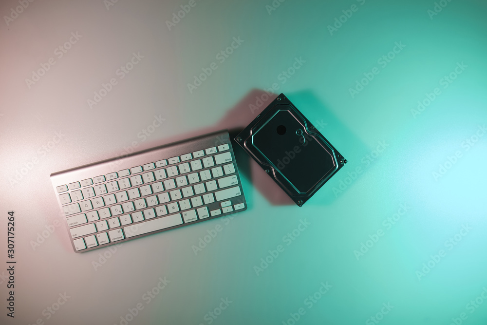 Aufkleber beautiful modern silver keyboard in the color light on a table and night background. top view.