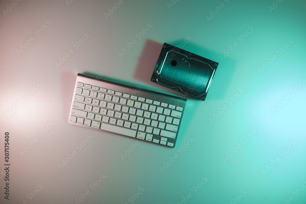 Aufkleber beautiful modern silver keyboard and hard disk in the color light on a table night background. top v