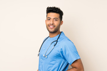 Young handsome man over isolated background with doctor gown