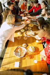 Happy co-workers celebrating while company party and corporate event. Young caucasian people in casual clothes cheering and laughting. Concept of office culture, teamwork, friendship, holidays