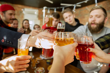 Happy co-workers celebrating while company party and corporate event. Young caucasian people in casual clothes cheering and laughting. Concept of office culture, teamwork, friendship, holidays