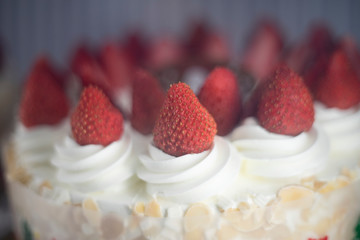 Fresh strawberry topping over whipping cream on cake