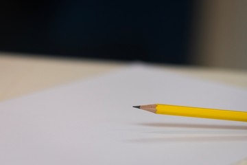 Yellow pencil on white paper