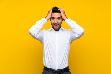 Young handsome man over isolated yellow background with surprise facial expression