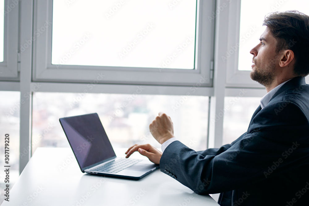 Poster businessman working on his laptop in office