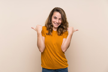 Young blonde girl over isolated background with thumbs up gesture and smiling
