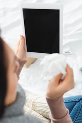 cropped view of ill woman with napkin having online consultation with doctor on digital tablet