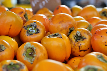 Bunch of kakis stacked in a market stall