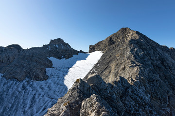 View to the rocky summit of Rote Wand mountain with it`s glacier under blue sky. Vorarlberg, Austria