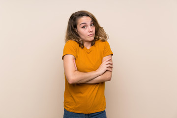 Young blonde girl over isolated background making doubts gesture while lifting the shoulders
