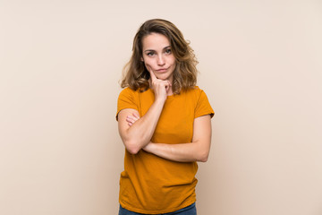 Young blonde girl over isolated background Looking front