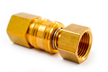 Close-up pneumatic quick coupling made of high-quality yellow metal, close-up shot on a white background