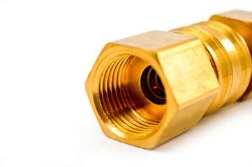 Close-up pneumatic quick coupling made of high-quality yellow metal, close-up shot on a white background