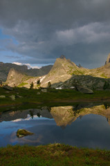 Naklejka na ściany i meble Reflection of a mountain peak in a mountain lake