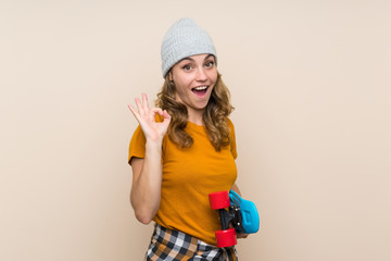 Young skater blonde girl making OK sign over isolated background