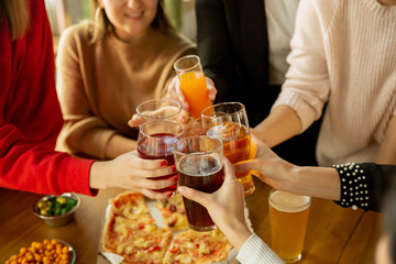 Happy co-workers celebrating while company party and corporate event. Young caucasian people in casual clothes cheering and laughting. Concept of office culture, teamwork, friendship, holidays