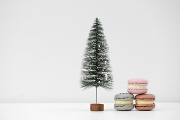 Christmas tree and french macaroons or macarons dessert on a white background. sweets under the Christmas tree