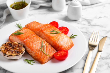 Delicious roasted fish served on white marble table