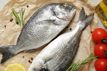 Flat lay composition with raw dorada fish on table