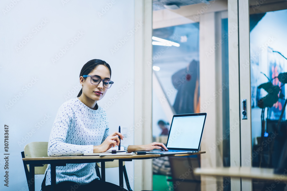 Poster pensive woman preparing for examination in college making notes using laptop computer with blank scr