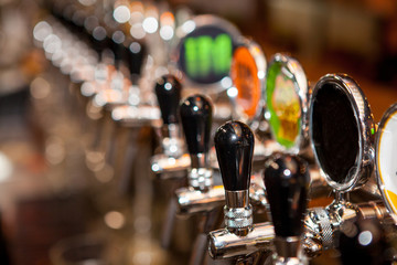 Row of Beer Taps in Bar for different types of drink. Bar interior