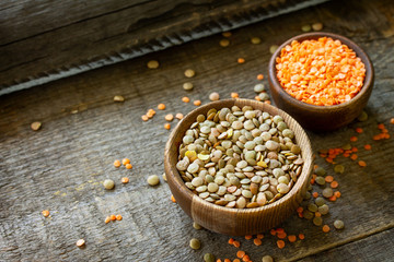 Healthy food, dieting, nutrition concept, vegan protein source. Raw legumes - red lentils and canadian lentils on wooden table. Copy space.