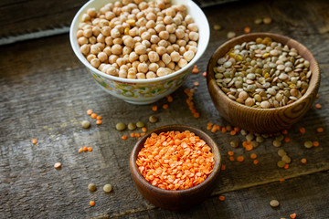 Healthy food, dieting, nutrition concept, vegan protein source. Raw legumes - red lentils and canadian lentils on wooden table. Copy space.