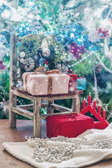 Christmas presents lie on a decorative small chair under the Christmas tree. New Year's decoration