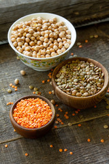 Healthy food, dieting, nutrition concept, vegan protein source. Raw legumes - red lentils and canadian lentils on wooden table.