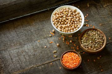 Healthy food, dieting, nutrition concept, vegan protein source. Raw legumes - red lentils and canadian lentils on wooden table. Copy space.