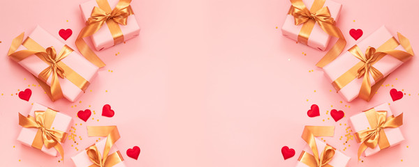 Valentine's Day banner. Pink gift boxes with gold bow with love red shape on pink background. Flat lay, top view, copy space.