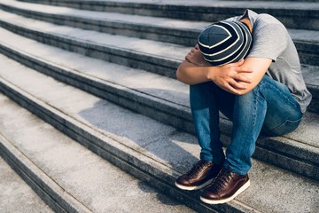 image of young man sitting on a stairway,depression