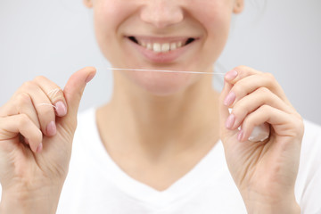 Dental hygiene and care. Dental floss. Young healthy woman face with beauty smile. Beautiful girl....