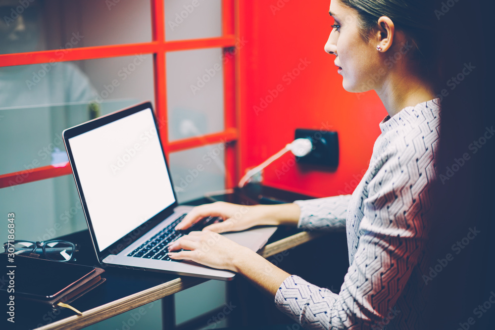 Aufkleber serious female manager typing on laptop computer with mock up screen making preparation for making s