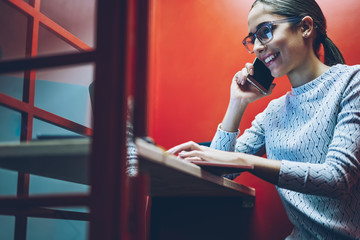 Happy female entrepreneur satisfied with productive business communication sitting in cabin with...