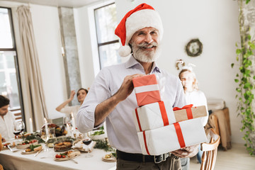 Smiling senior man holding Christmas presents