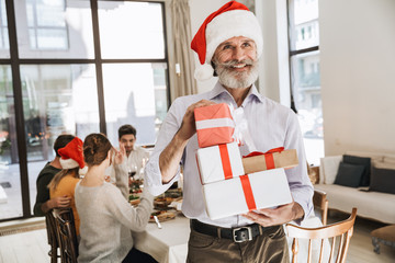 Smiling senior man holding Christmas presents