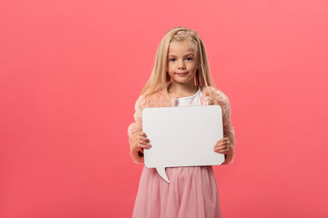 cute and smiling kid holding empty speech bubble isolated on pink