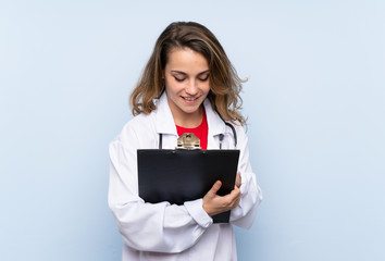 Young blonde woman with doctor gown and writing in a folder