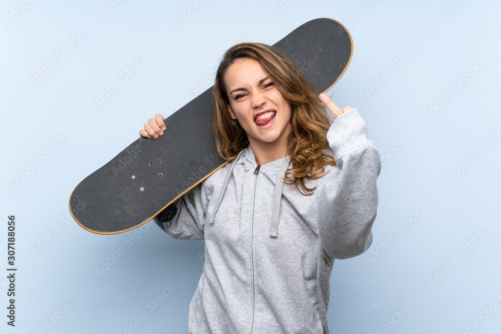 Wall mural Young blonde woman with skate