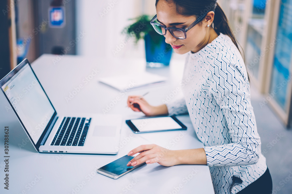 Aufkleber brunette businesswoman working in office checking notification on smartphone synchronizing netbook f