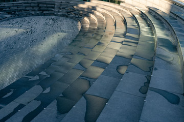 modern stairs - the amphitheatre in the city centre. London, a public space. Semicircular stairs after a rain.
